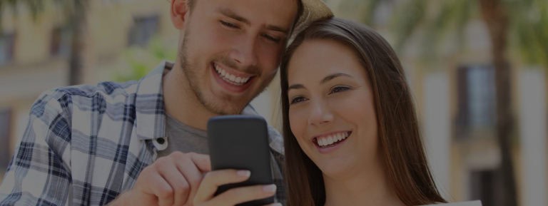 happy couple looking at phone